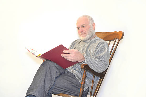 old man reading in rocking chair